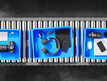 blue bins at security gate with laptops, keyboards and headphones
