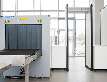 airport security terminal with luggage belt, metal detector and a turnstile