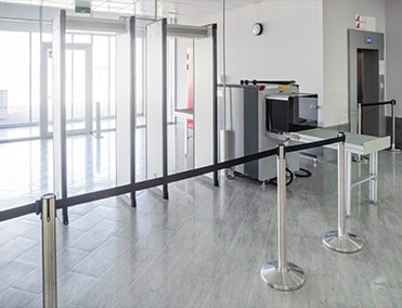 security gate with two metal detectors and a luggage conveyor belt at an airport